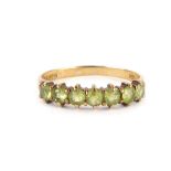 A 9ct gold half hoop eternity ring, set with seven pale green stones, with two splayed shoulders, ri