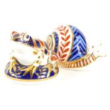 Two Royal Crown Derby porcelain paperweights, a snail with gold coloured stopper, and a frog with go