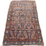 A Persian rug, with an all over design of flowers, leaves, etc., in red and pale blue, on a navy gro