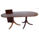 A mahogany extending dining table in Regency style, the top with a reeded edge on two turned columns