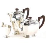 A George VI silver three piece tea service, comprising teapot, hot water jug, milk jug, with ebonise