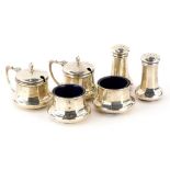 A George V silver cruet set, comprising two mustard pots, with hinged lids, enclosing two open salts