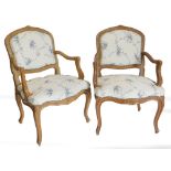 A pair of French style hardwood fauteuil, each with a moulded frame, upholstered in blue and cream f