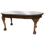 An early 20thC mahogany extending dining table, the oval top with a rope twist carved border, on bul