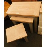 A nest of three light oak nest of tables, with grey painted bases.