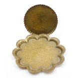 Two Eastern brass trays, to include a circular tray with central medallion, 17cm wide, and a scallop