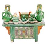 A Chinese Tang style sancai pottery model of a cabinet, festooned with food and pottery vessels in t