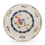 A Chinese porcelain plate, decorated with a central roundel of flowers with a scrolling underglaze b