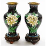 A pair of Chinese cloisonne baluster vases, on a black ground with blue borders and cream and pink f
