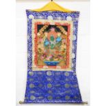 A Tibetan thangka depicting the green goddess, Mother Tara, on blue Brocade mount, 130cm x 71cm.