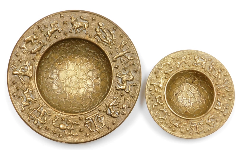 Two hammered brass bowls, each with zodiac borders, 21.5cm and 14.5cm wide. (2)