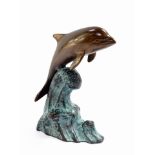 A bronze figure of a dolphin riding the wave, 15cm high.
