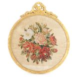 A Victorian woolwork picture decorated with flowers, within a gilt wood and gesso circular frame, 49