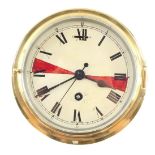 An early 20thC brass ship's clock, enamel dial bearing Roman numerals, with key, 20.5cm diameter.