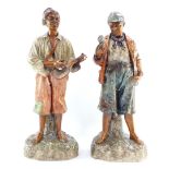 A pair of Victorian plaster figures of black urchins, modeled standing, one holding a mandolin, the