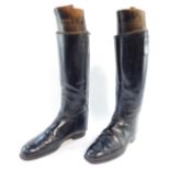 A pair of black leather riding boots, with wooden stays.