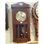 An oak cased mantel clock, with applied fleur de lys finial, silver coloured dial, with pendulum and