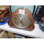 An oak cased mantel clock, in the 1950's/60's style, with a silvered coloured dial.