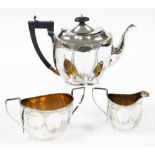 A George V silver Neo Classical design three piece tea service, bright cut decorated with bow drops,