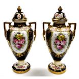 A pair of Noritake two handled vases and covers, each on a black ground with floral gilt detailing,