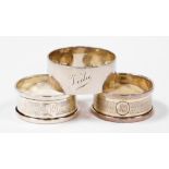 Three George V silver napkin rings, to include a pair of engine turned decorated napkin rings, with