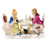 A Continental porcelain figure group, of card players in 18thC dress seated at a table, 26cm wide.