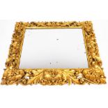 A 19thC giltwood and gesso wall mirror, in the rococo style with heavy scroll and acanthus leaf deta