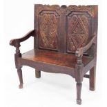 A late 19thC oak settle, with two seat panel back, with flowers and scroll detailing, 107cm high, 92