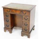A mahogany kneehole desk, the rectangular top with green leather inset above one long drawer with th