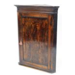 A George III mahogany hanging corner cabinet, with moulded cornice and single door, 105cm high, 79cm