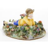 A Royal Staffordshire figure group, of a boy lying in flower garden, modelled by Bagley, with green