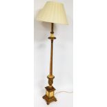 A gilt standard lamp, in gold with cream detailing, on a stepped base with cream shade, 172cm high.