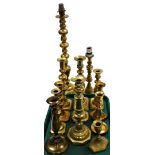 A quantity of Victorian and later brass candlesticks, two converted to lamps, and various others in