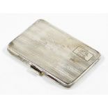 A George V silver cigarette case, with engine turned decoration and crest bearing the initials VEC,