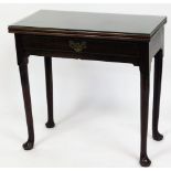 A George III mahogany side table, with fold over top and frieze drawer, on turned legs with pad feet