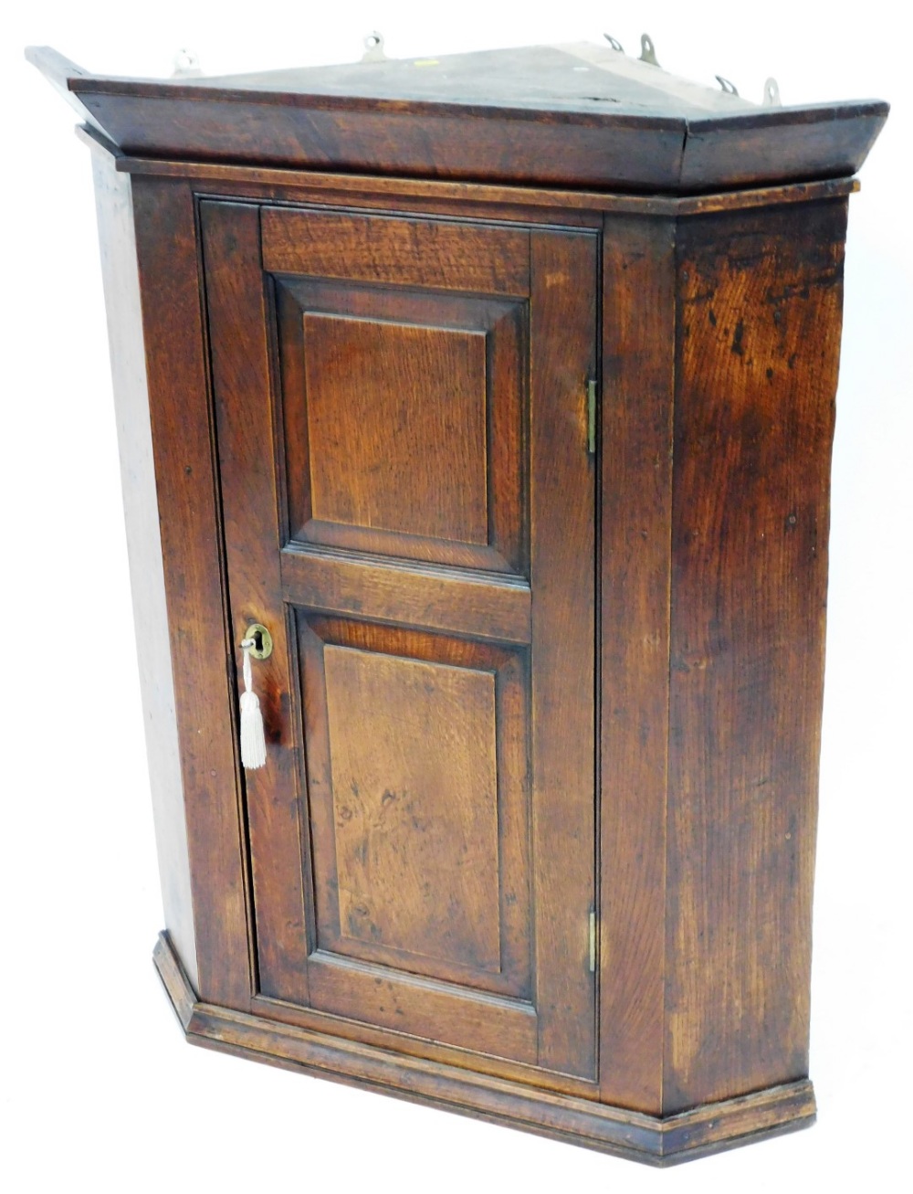 A George III oak corner cabinet, with two panelled door on moulded cornice, with brass key plate, 10