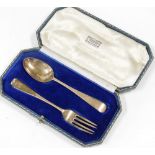 A silver cased christening set, retailed by Harrods of London, comprising fork and spoon, each beari