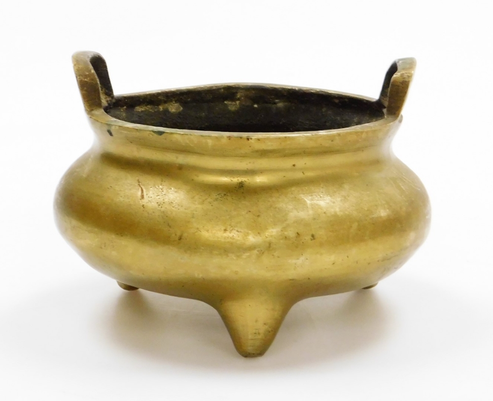 A Chinese bronze tripod censer, with two loop handles, cast mark with lengthy inscription, 13cm high