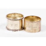 Two silver napkin rings, to include one with floral design border bearing the initials TC, Sheffield