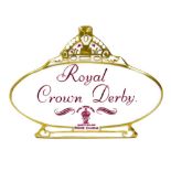 A Royal Crown Derby retailers' plaque, with crown top on an oval plaque with purple stamp and writin