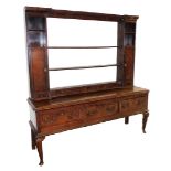 A George III oak dresser, with plate rack top centred above two open sections and single door and dr