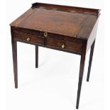 An early 19thC oak clerk's desk, with tray top central lift lid section above two drawers with brass