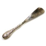 A silver handled shoe horn, bearing the initials MR, with cherub and foliate scrolling, 24cm long.