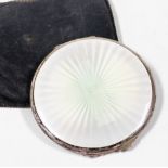 A silver and enamel compact, the top lid cream and green lustre enamel, opening to reveal powder com