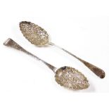 Two William IV silver berry spoons, each with foliate decorated top, and heavy embossed floral bowl,