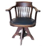 A oak swivel captain's chair, with lath back and black leather inset seat.