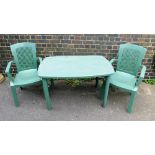 A green plastic garden table and two chairs.