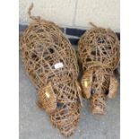 Two wicker garden pigs, the largest 66cm long, the smallest 58cm long, and each approximately 32cm h