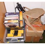 A group of camera equipment, to include a slide projector, various slide reels, camera bag and tripo