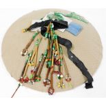 A lace makers pin cushion with various lace bobbins, wooden with beaded ends.